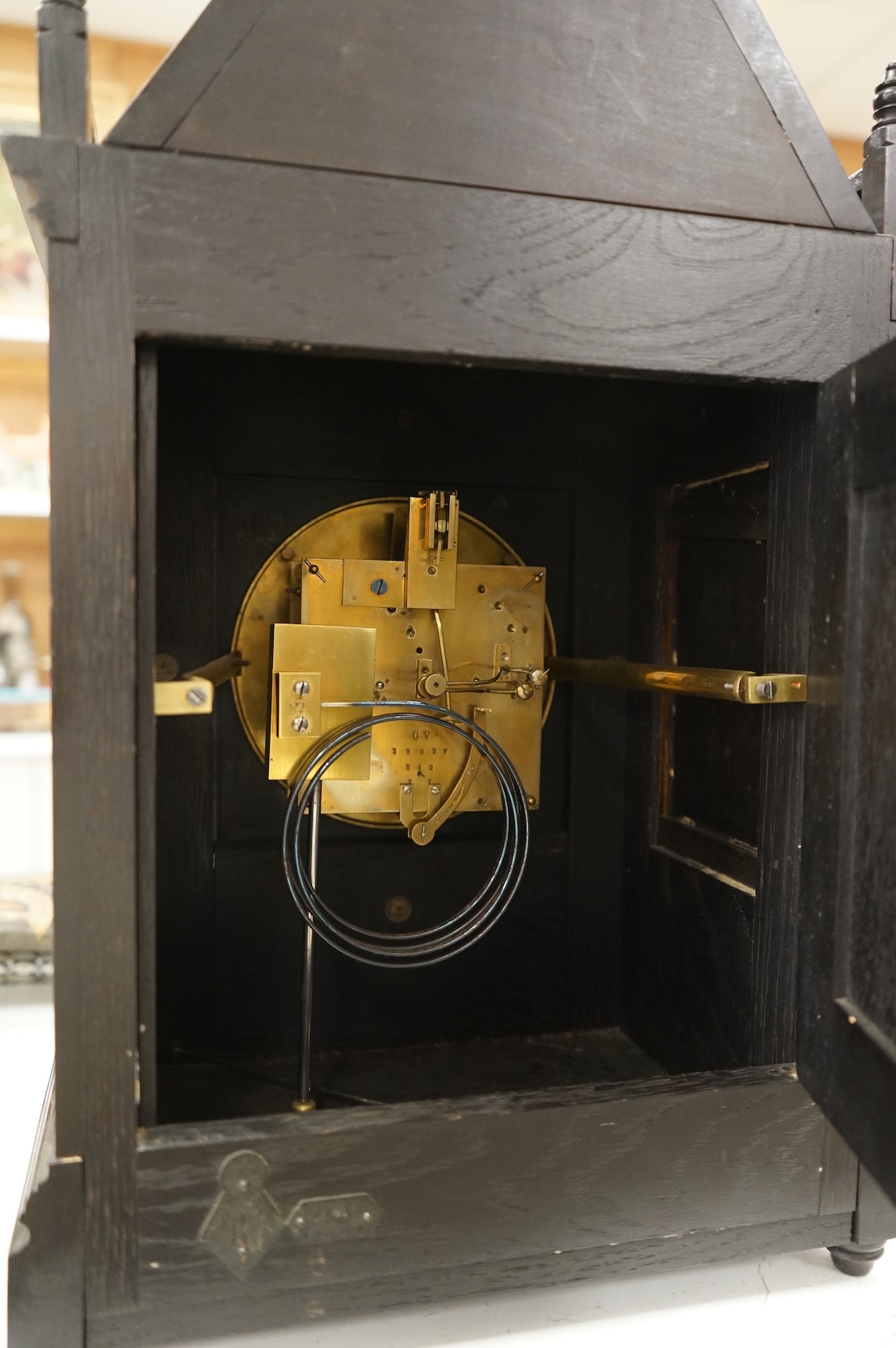 A Victorian Aesthetic Movement ebonised architectural mantel clock, probably designed by Lewis Foreman Day, the eight day chiming movement marked G.V. no. 39837, with Elourdelet lever, with figure and foliage decorated g